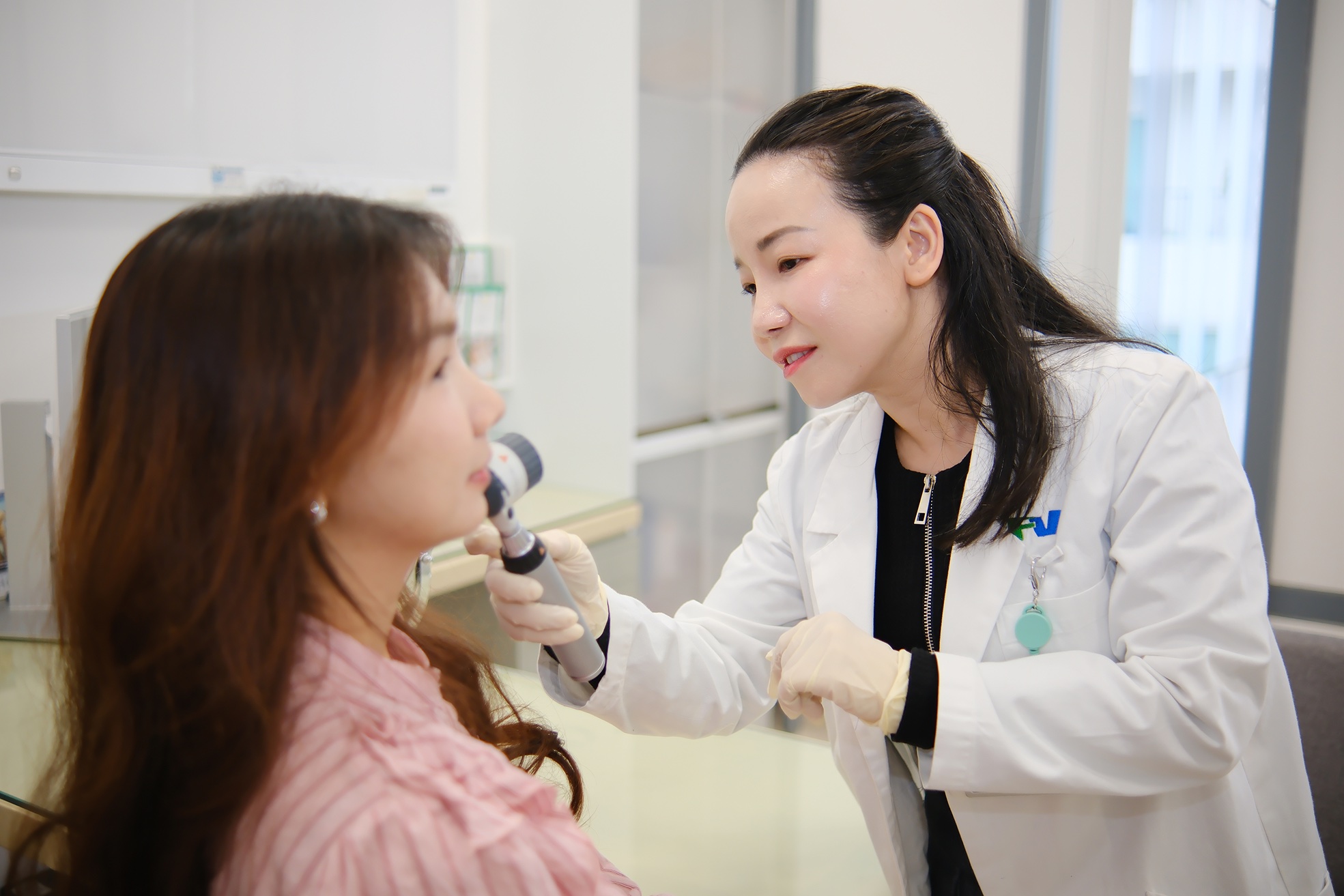Dr Nguyen Kim Phuong examining a patient's skin before laser treatment