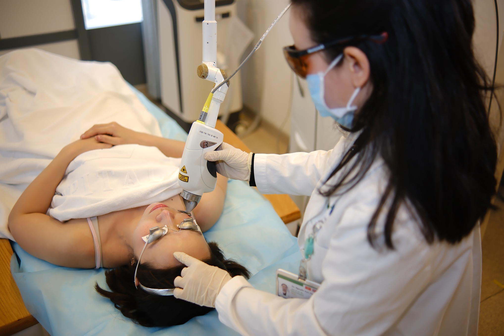 Dr Nguyen Kim Phuong performing a laser treatment on a patient's face